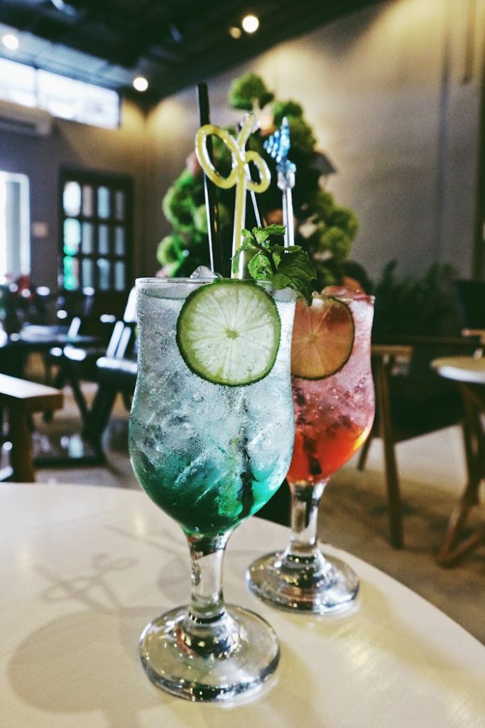 Refreshing cocktails with lime garnish served in a cozy indoor bar setting.